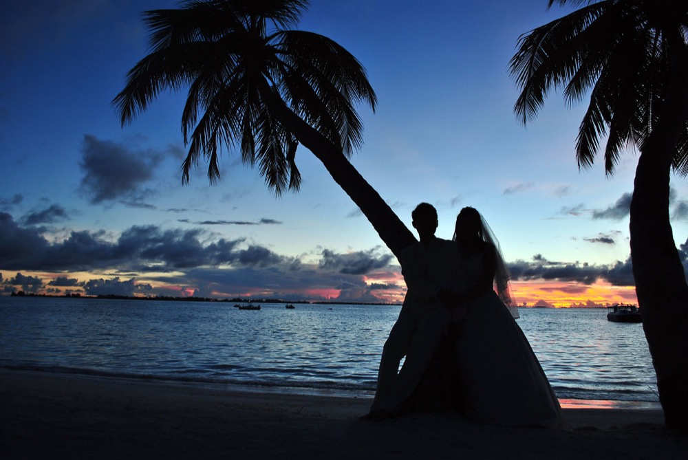Couple watching the sunset on a beach getaway